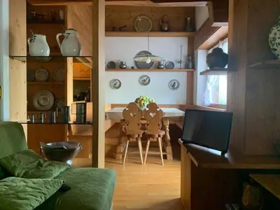 a living room with a couch and a table with chairs at Cortina central apartment overlooking Tofane Faloria in Cortina dʼAmpezzo