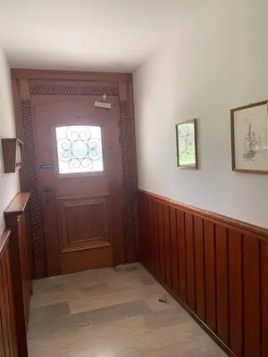 a hallway with a wooden door and a window at Cortina central apartment overlooking Tofane Faloria in Cortina dʼAmpezzo