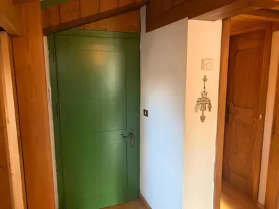 a green door in the corner of a room at Cortina central apartment overlooking Tofane Faloria in Cortina dʼAmpezzo