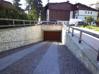 a tunnel in a stone wall next to a road at Cortina central apartment overlooking Tofane Faloria in Cortina dʼAmpezzo
