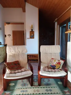 two white chairs sitting in a living room at Casa Claudia in Carano