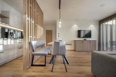 a kitchen with two chairs and a table in a room at Tieja Panoramic Lodge in Selva di Val Gardena