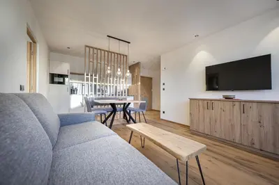 a living room with a couch and a table at Tieja Panoramic Lodge in Selva di Val Gardena