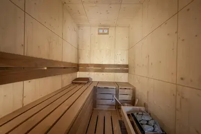an empty sauna with wooden walls and wooden floors at Tieja Panoramic Lodge in Selva di Val Gardena