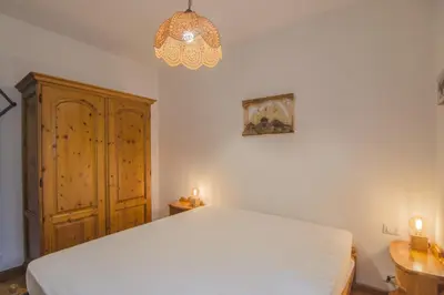 a bedroom with a white bed and a chandelier at Ca Masarie in Alvera
