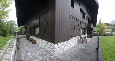 a building with a stone patio next to a building at Ca Masarie in Alvera