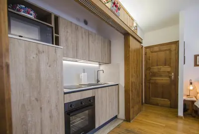 a kitchen with wooden cabinets and a sink and a stove at Ca Masarie in Alvera