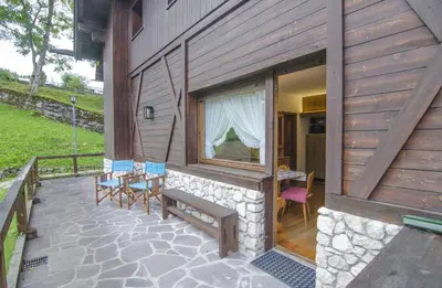 a patio with a bench and a table and chairs at Ca Masarie in Alvera