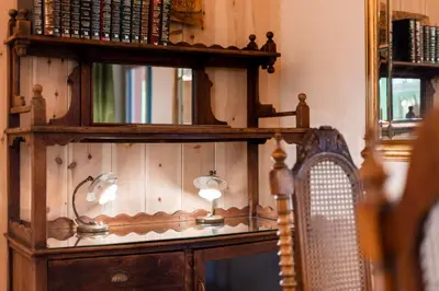 a room with a wooden shelf with lamps and a chair at Wohnung ASSUNTA in Soprabolzano