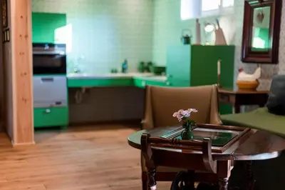 a kitchen with green cabinets and a table with flowers on it at Wohnung ASSUNTA in Soprabolzano