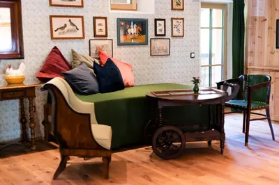 a bed with colorful pillows and a table in a room at Wohnung ASSUNTA in Soprabolzano