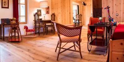 a living room with wooden floors and chairs and a table at Wohnung FRIEDRICH in Soprabolzano