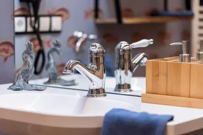 a bathroom sink with two faucets and a wooden block at Wohnung GEORG-OTTO in Soprabolzano
