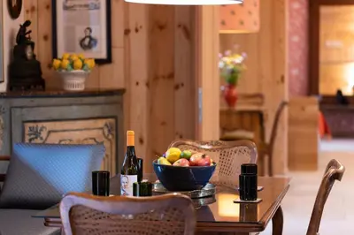 a table with a bowl of fruit and a bottle of wine at Wohnung GEORG-OTTO in Soprabolzano