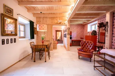 a living room with a table and a chair at Wohnung PAUL in Soprabolzano