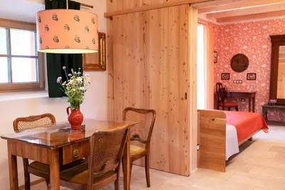 a dining room with a table and a bedroom at Wohnung PAUL in Soprabolzano