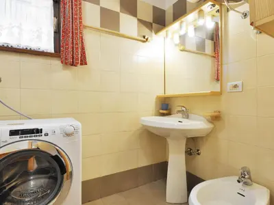 a bathroom with a washing machine and a sink at Apartment Apt 1 by Interhome in Penia