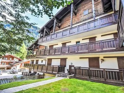 a building with a snow covered tree in front of it at Apartment Marmolada-12 by Interhome in Alba di Canazei