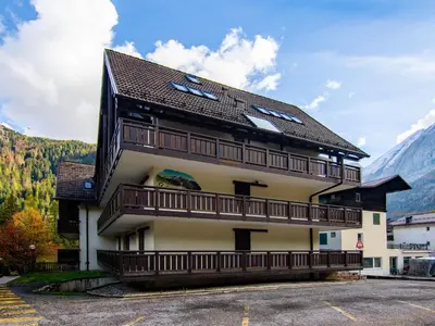 a building with cars parked outside in the snow at Apartment Marmolada-12 by Interhome in Alba di Canazei