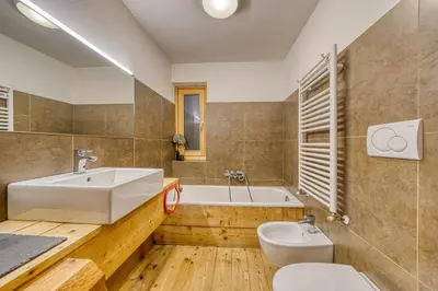 a bathroom with a sink and a tub and a toilet at Luxchalet a pochi minuti dal centro in Cortina dʼAmpezzo