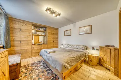 a bedroom with a bed in a room with wooden walls at Luxchalet a pochi minuti dal centro in Cortina dʼAmpezzo