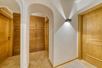 an arched hallway with wooden walls and a light fixture at Luxchalet a pochi minuti dal centro in Cortina dʼAmpezzo
