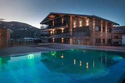 a large swimming pool in front of a building at Suitehouse, Premium Apartments, Pools & Spa in Dolomites - by Familiaris in Valdaora