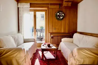 a living room with two white couches and a table at Corso Italia Apartment - Magical view of the Dolomites in Cortina dʼAmpezzo