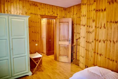 a bedroom with wooden walls and a door and a bed at Corso Italia Apartment - Magical view of the Dolomites in Cortina dʼAmpezzo
