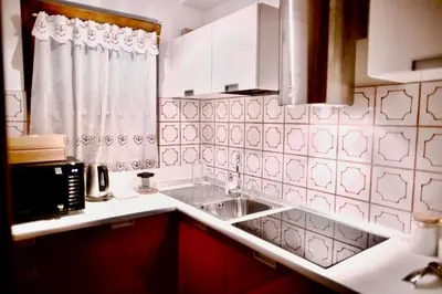a kitchen with a sink and a microwave at Corso Italia Apartment - Magical view of the Dolomites in Cortina dʼAmpezzo