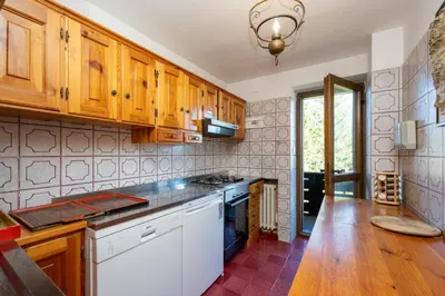 a kitchen with wooden cabinets and a stove top oven at Villa Diana in Cortina dʼAmpezzo