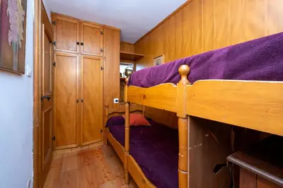 a bedroom with two bunk beds with purple sheets at Villa Diana in Cortina dʼAmpezzo