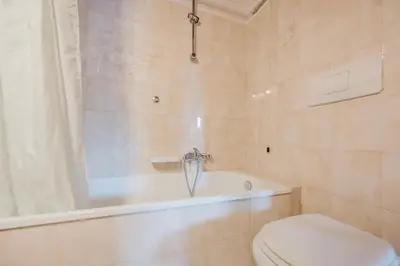 a bathroom with a tub and a toilet and a shower at Ca' Alpini - Mountain View Terrace & Parking in Cortina dʼAmpezzo