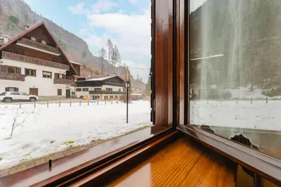 a window with a view of a snow covered street at Sasso Bianco Home - Mountain View & Private Parking in Sottoguda