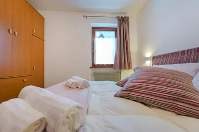 a bedroom with a bed with towels on it at Sasso Bianco Home - Mountain View & Private Parking in Sottoguda