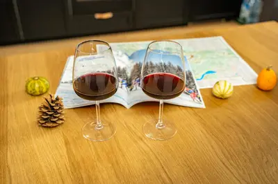 two glasses of red wine sitting on a table at MH Luxury Apartments in Cavalese