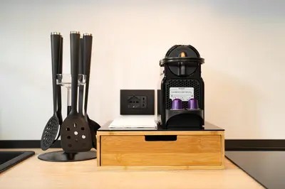 a coffee maker sitting on top of a wooden table at MH Luxury Apartments in Cavalese