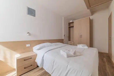 a bedroom with a large white bed with towels on it at Casa Scola in Falcade