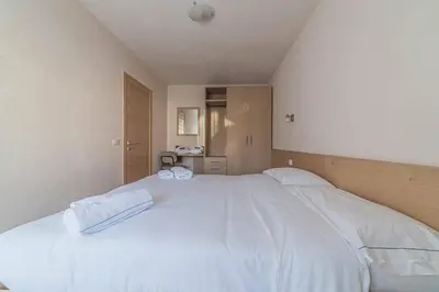 a bedroom with a large bed with white sheets at Casa Scola in Falcade