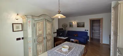 a living room with a table and a blue couch at Casa Aloch da Aldo Gianni in Pozza di Fassa