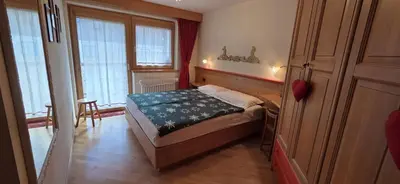 a small bedroom with a bed and a table at Casa Aloch da Aldo Gianni in Pozza di Fassa
