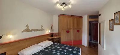a bedroom with a bed and a table in it at Casa Aloch da Aldo Gianni in Pozza di Fassa