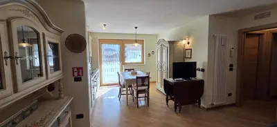 a dining room with a table and chairs and a television at Casa Aloch da Aldo Gianni in Pozza di Fassa