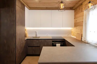 a kitchen with wooden cabinets and a counter top at Casa Gerda nel cuore di Cortina d'Ampezzo in Cortina dʼAmpezzo