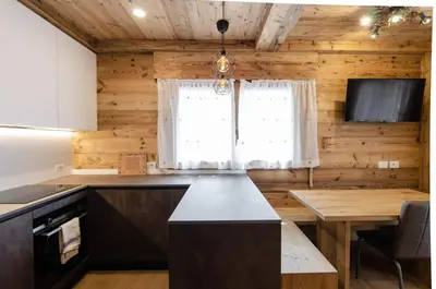 a kitchen with a table and a window at Casa Gerda nel cuore di Cortina d'Ampezzo in Cortina dʼAmpezzo