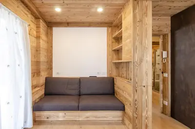 a couch in a room with wooden walls at Casa Gerda nel cuore di Cortina d'Ampezzo in Cortina dʼAmpezzo