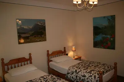 a bedroom with two beds and a painting on the wall at Casa Basilio in Predazzo