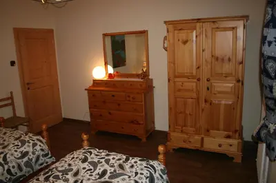 a bedroom with a dresser and a mirror and a bed at Casa Basilio in Predazzo