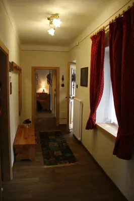 a hallway of a home with a room with a window at Casa Basilio in Predazzo