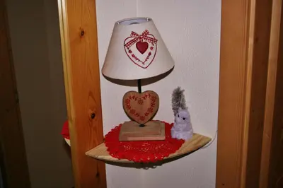 a lamp on a shelf with a cat and a heart at Casa Basilio in Predazzo